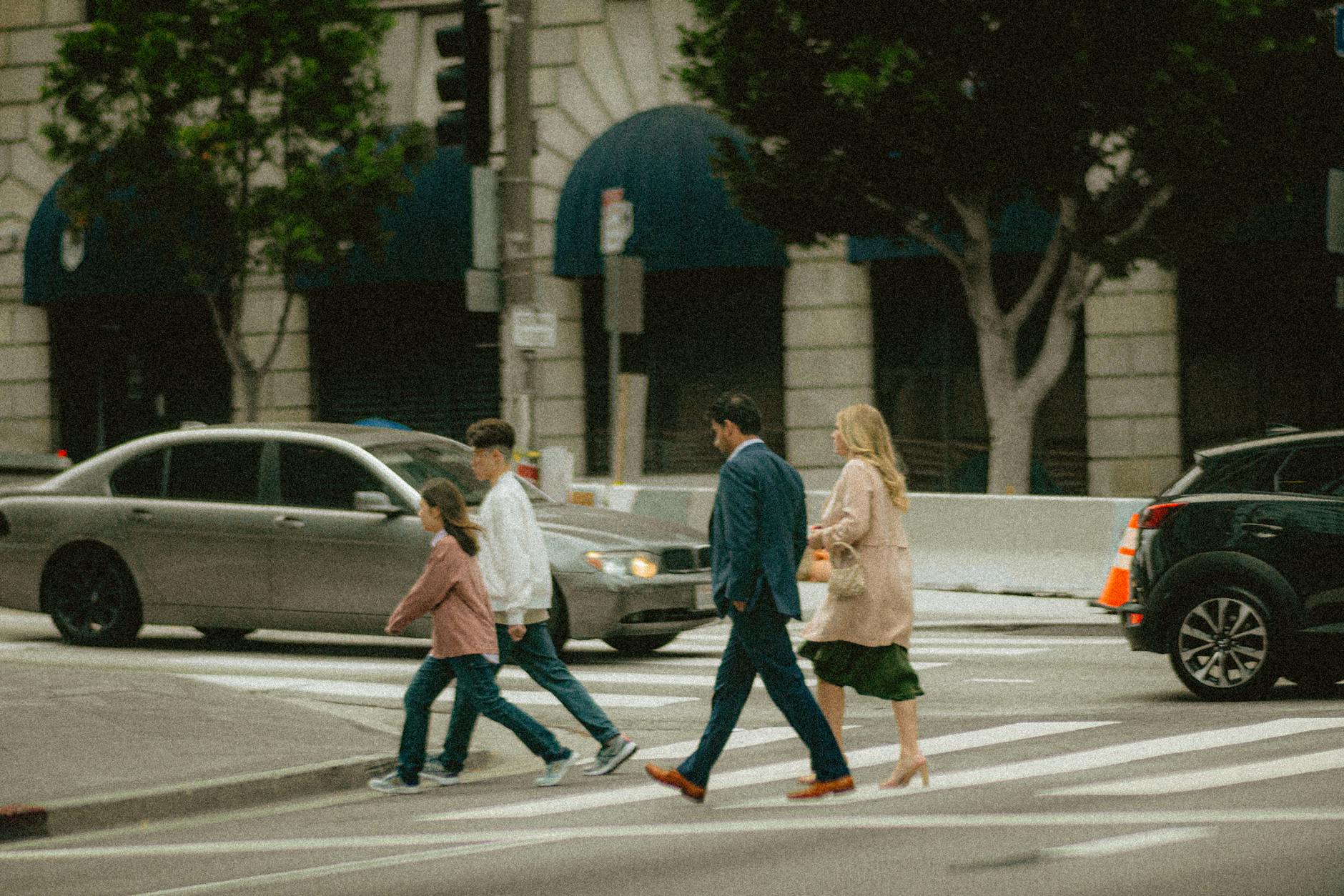 Rodzina z dziećmi przechodzi przez pasy na ruchliwej ulicy w Warszawie