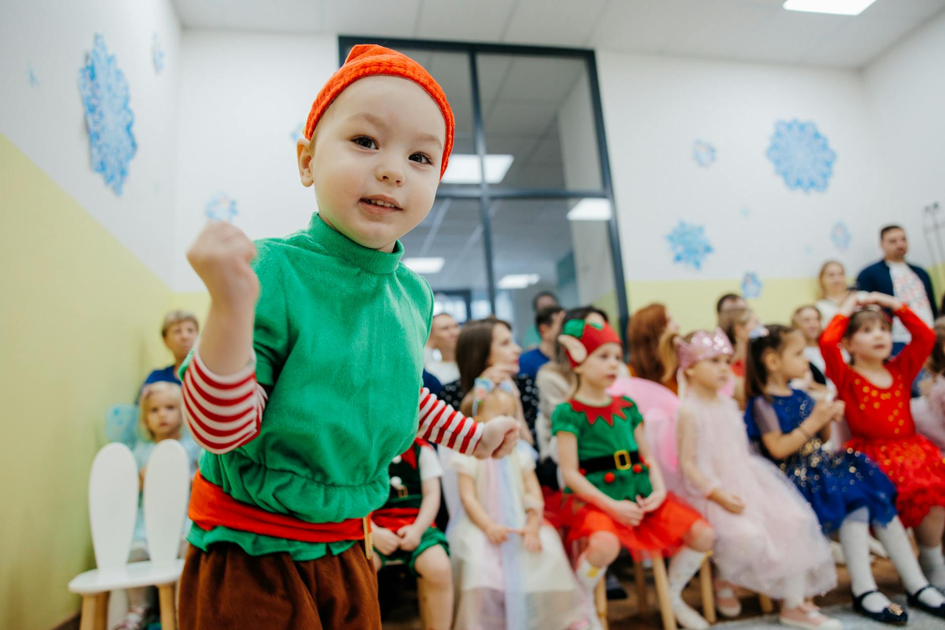 Dzieci w kolorowych strojach bawiące się na zimowym szkolnym wydarzeniu