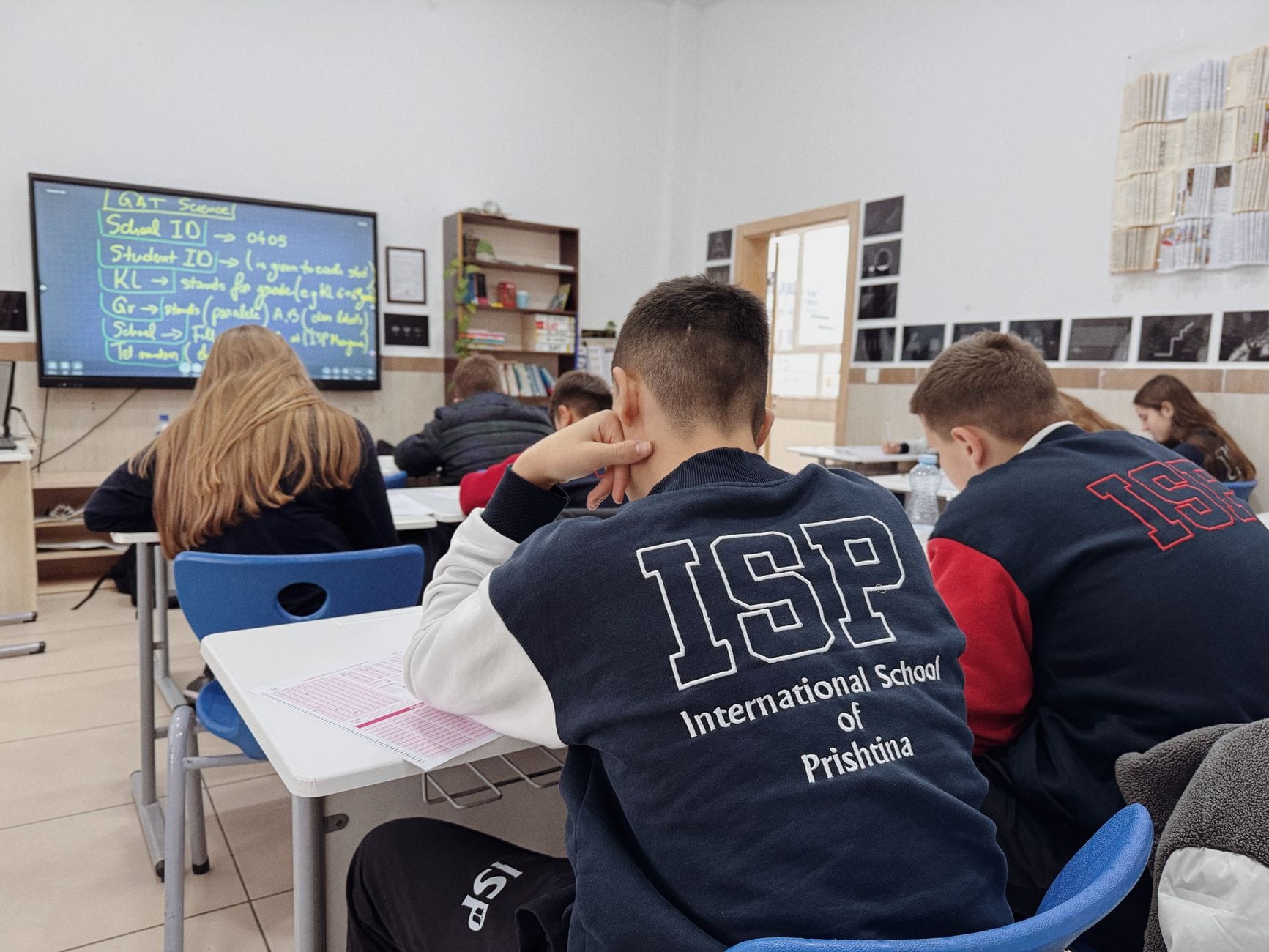Uczniowie międzynarodowej szkoły słuchają nauczyciela w klasie